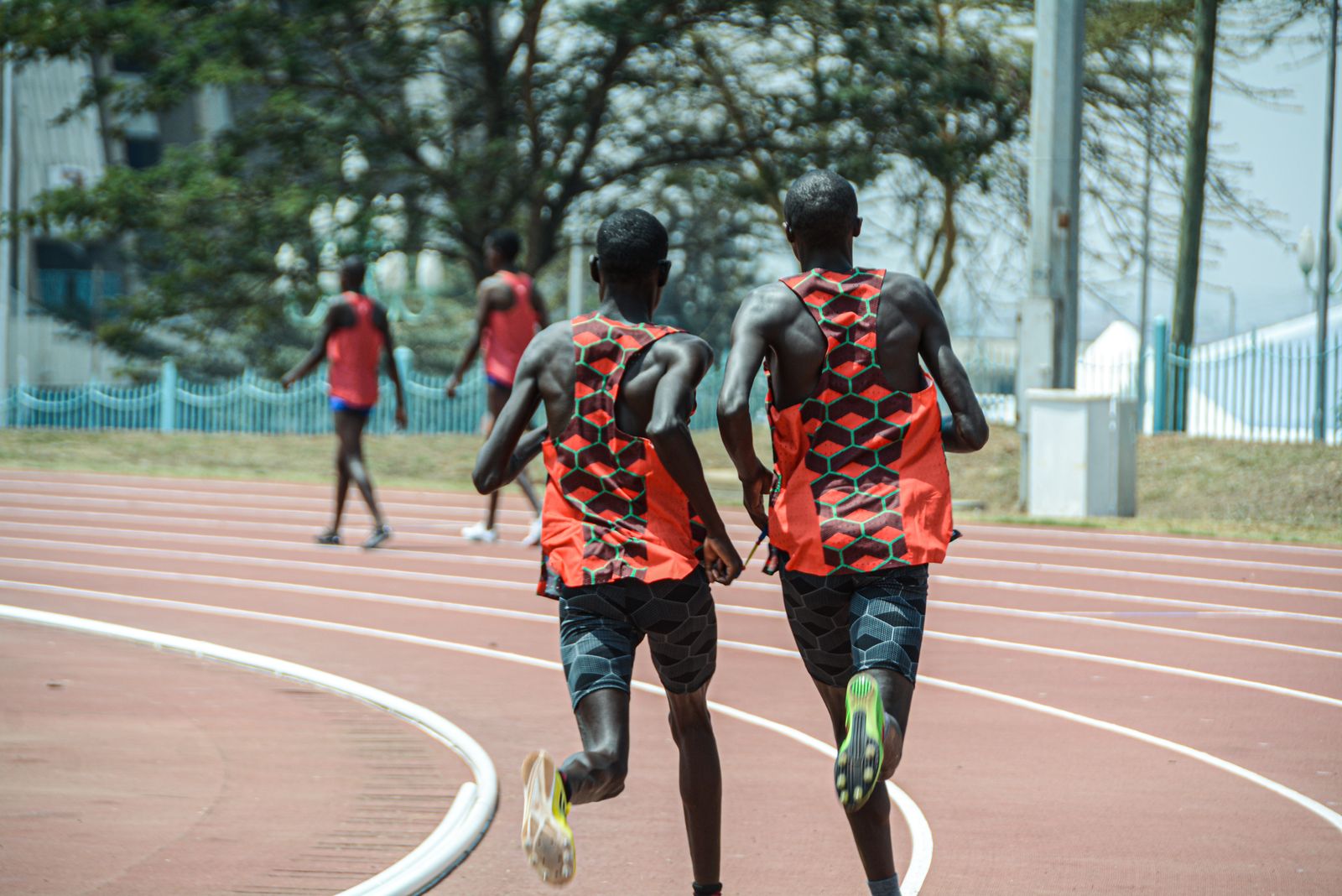 Athlete mid-stride on an outdoor track at dusk